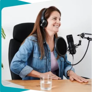 Formadora sonriendo mientras realiza una sesión online con micrófono y auriculares.